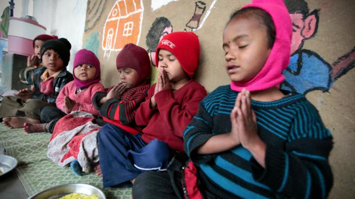 At the crèche, children receive food, education, healthcare, and access to clothing for purchase at low prices. Here, a nondenominational prayer before mealtime. Children on the construction sites come from India's various faiths: Hindu, Muslim, Sikh, and more.