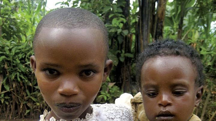 A war-affected girl in Rwanda cares for her younger sibling.