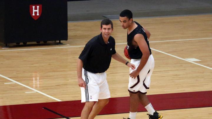 Besides discussing how he approaches coaching, Boston Celtics head coach Brad Stevens (at left) ran drills with members of the Harvard club basketball team, including James McCaffrey ’15.