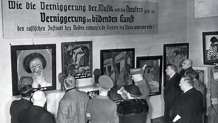 Harvard eventually acquired a Van Gogh self-portrait and the Emil Nolde painting The Mulatto, seen at far left in this photograph of visitors to the Exhibit of Degenerate Art.