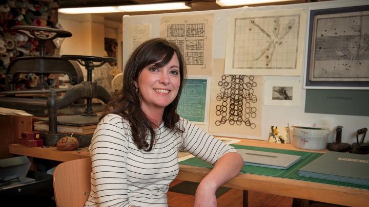 Hulsey in her studio, with letterpress machines behind her