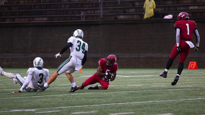 Harvard's B.J. Watson falls to the ground with the ball.