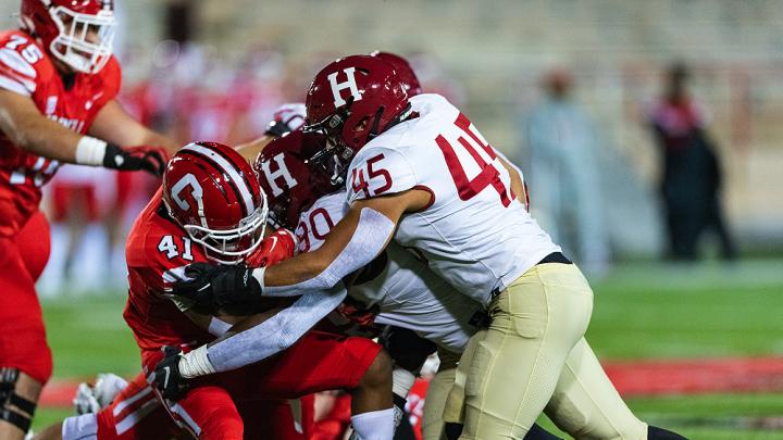 Cornell running back Eddy Tillman finds his path blocked by Harvard defenders. The Crimson limited the Big Red to 65 yards on 37 carries.