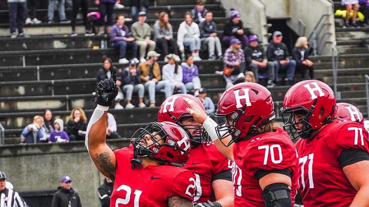 Harvard running back Aidan Borguet celebrates one of his two touchdowns with senior offensive linemen Scott Elliott and Alec Bank.