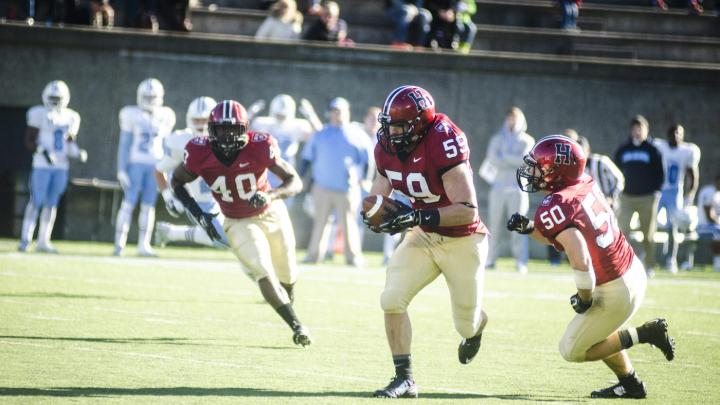 Convoyed by fellow linebackers Dominique Packer ’17 (number 40) and Connor Sheehan ’15 (50),  Matt Koran ’16  took this first-quarter interception for a touchdown, one of the Crimson's record-setting three runbacks for scores. Koran's pick-six was sandwiched between a pair by Sheehan. 