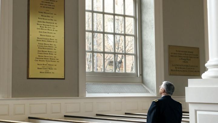 In Memorial Church, General George W. Casey Jr. views the plaque commemorating the Harvard dead of the Vietnam War, among them his father, George W. Casey ’45.