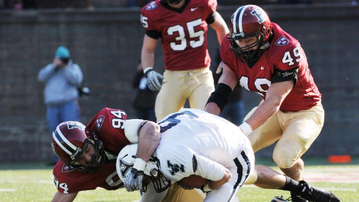 Senior linebacker Nick Hasselberg (94) was in on 20 tackles, tying a single-game Harvard record set in 1999 by Isaiah Kacyvenski ’00. Above, he wraps up Eli wideout Cameron Sundquist after a four-yard pass reception in the opening period. Trailing the play is linebacker Alex Gedeon (49). 