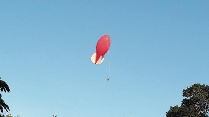 After an all-night experiment, dawn illuminates the balloon while the students take a final set of measurements