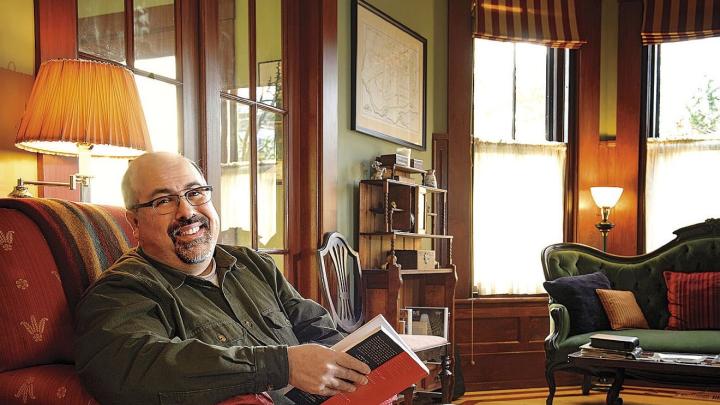 Poet and physician Rafael Campo relaxes at home with a book. 