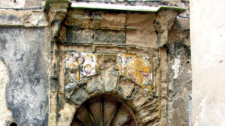 Note the intact Roman keystone and distinctively Portuguese spoke-wheel woodwork in this weathered door in Essaouira, Morocco (2006).