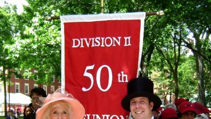 Betty Breck and marshal Don DeSollar flank the reunion banner, with members of the Class of 1960 in the background, prepared to march in the alumni/ae procession at the 2010 Commencement.