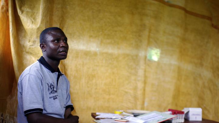 Physician Joshua Mukhama in the space where he conducts counseling: a gazebo with a sheet hung to separate the counseling area from the waiting area