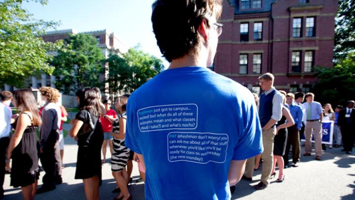 Peer advising fellows in blue tees and members of the Crimson Key Society in red tees cheered on the first-years entering Tercentenary Theatre.