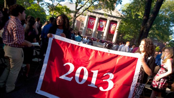 Seniors Kia J. McLeod (left) and Andrea R. Flores, vice president and president of the Undergraduate Council, display the banner that they presented to the class of 2013.
