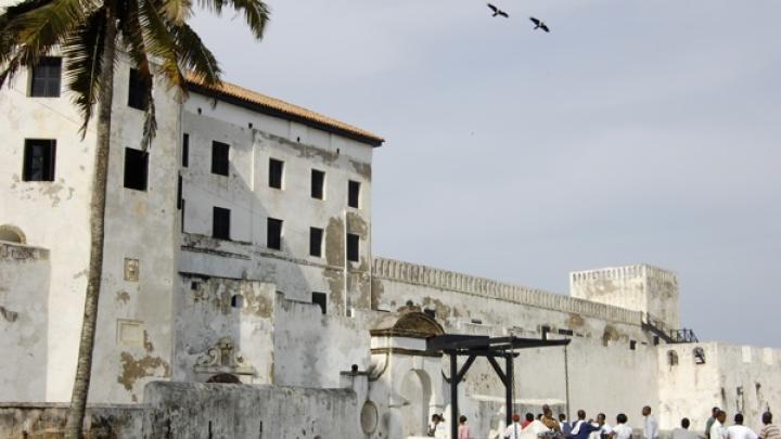 The entrance to St. George's Castle in Elmina, bustling with tourists and souvenir hawkers, demonstrates Ghana's role in the slave-tourism industry.