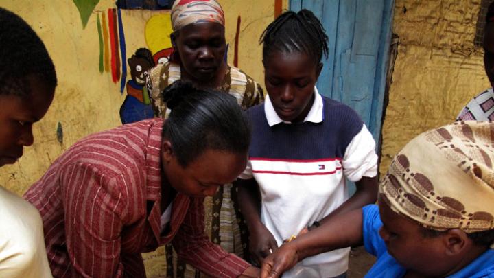 The people of Kibera are nothing if not resourceful. Here, the women use a candle flame to fuse together two ends of a piece of plastic, to form it into a loop they’ll use for a planter.