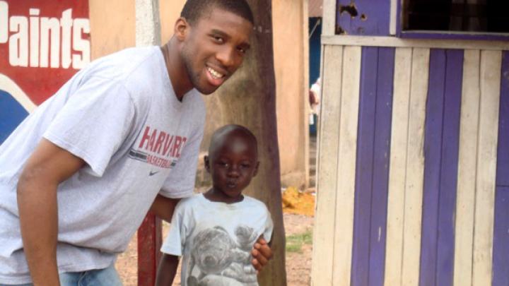 Visiting in 2008 to oversee construction of a borehole and latrines, Ndu Okereke ’10 (Project ACWA finance director, as well as a roommate of Delle and Finkton) hams it up with one of the village children.  