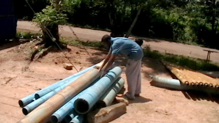 Okereke inspects the pipes used for the borehole.