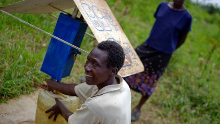 At another collection site near Busia, Loice Pamba adds chlorine before filling her water jug.