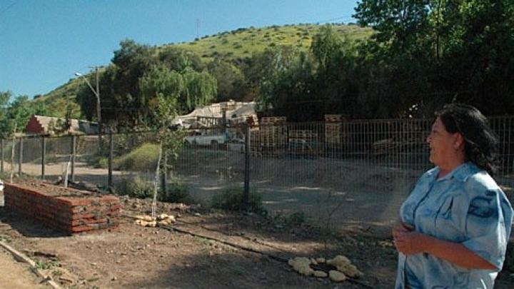 Ana Lamilla surveys the Renca development from the still-under-construction park on a ridge above. Behind her, part of the squatter settlement where she once lived remains.