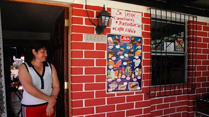 Herrera stands in the doorway of her home.
