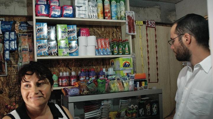 Marta Herrera, pictured with ELEMENTAL project manager Gonzalo Arteaga, has set up a small convenience store in the front room of her house at the Lo Espejo development.