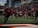 Harvard quarterback has the ball as Princeton players are in pursuit
