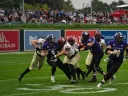 Holy Cross player has ball and Harvard players try to tackle with additional Holy Cross players in pursuit