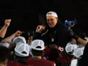 Coach Murphy is held up high by players in celebration
