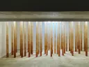 Yamamoto's installation, made of 20 orange tubes that stretch from floor to ceiling in a white room. 