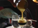 Pouring the creamy “Sai  Gon Latte” at Cicada Coffee Bar in Central Square