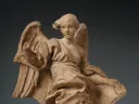 A clay sculpture of a robed angel. 