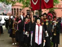 Law School graduates in black caps and gowns cheer 