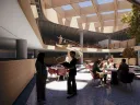 People sit at tables in a basement. Windows on the ceiling allow light in.