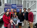 Senator Warren and Representative Ayanna Pressley with Harvard Democrats members in front of campaign signs for their re-election.