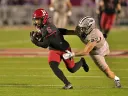 Harvard player 6 runs with the ball as UNH player attempts to tackle him