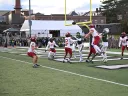 Several Harvard and Dartmouth players in end zone pursuing an air bound ball