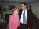 Ruth and Roman DeSanctis smiling at each other in a family living room, his arm around her shoulder