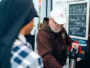 A friar serves drinks at a food truck labeled "Capuchin Mobile Ministries."