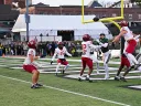 Harvard football players in red jerseys defending against Dartmouth's Hail Mary pass, ensuring victory.