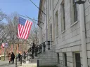 University Hall with a flag over the John Harvard Statue