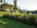 Garden view of Aspet, with vibrant flower beds and Mount Ascutney in the background.