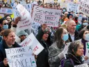 Crowd at Boston science rally holding protest signs opposing research funding cuts