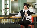 Jessica Shand holds a flute, seated in a music lab. 