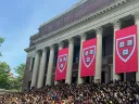 Commencement flags at Widener with students gathered on steps