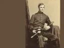 Oliver Wendell Holmes Jr. in a military uniform sits with a sword, looking at the camera.
