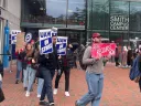 Picketers holding signs march outside the Smith Campus Center, advocating for labor rights.