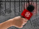 An image of a hand holding a microphone, representing a journalist