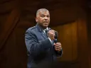 U.S. Air Force Lieutenant General Richard Clark in a military uniform speaks passionately into a microphone on stage.