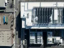 Aerial view of a large industrial data center facility with a flat roof and various equipment.
